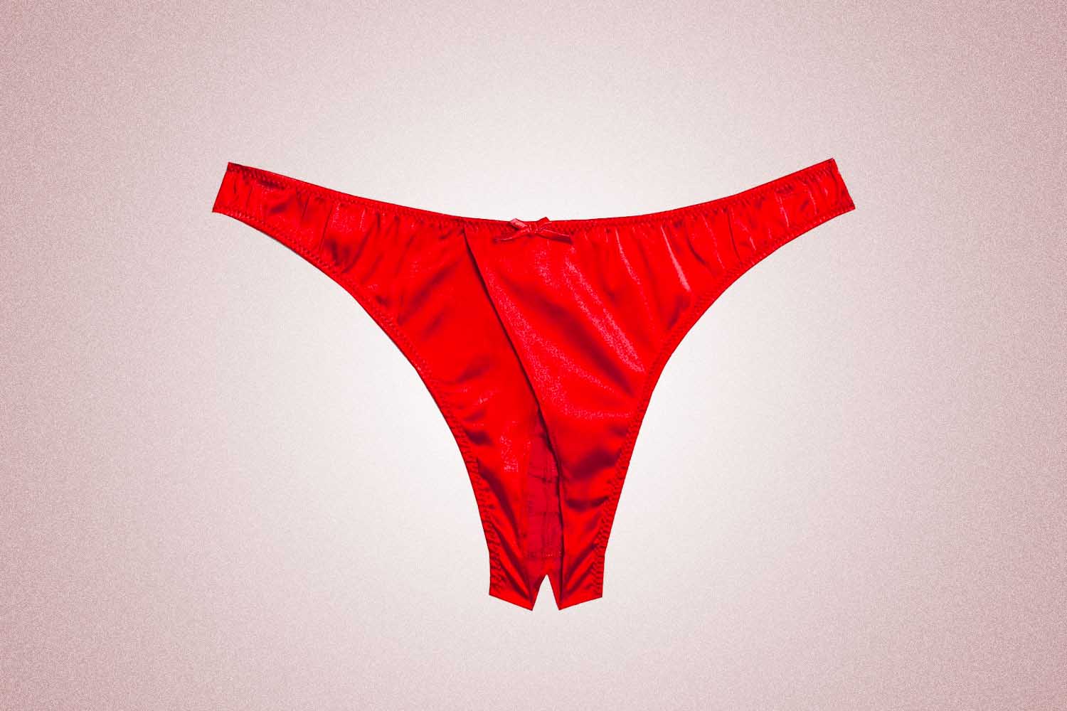 Red crotchless panties from Fleur du Mal, a perfect Valentine's Day gift, on a pink background. 