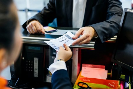 an airline passenger hands a ticket to a gate agent
