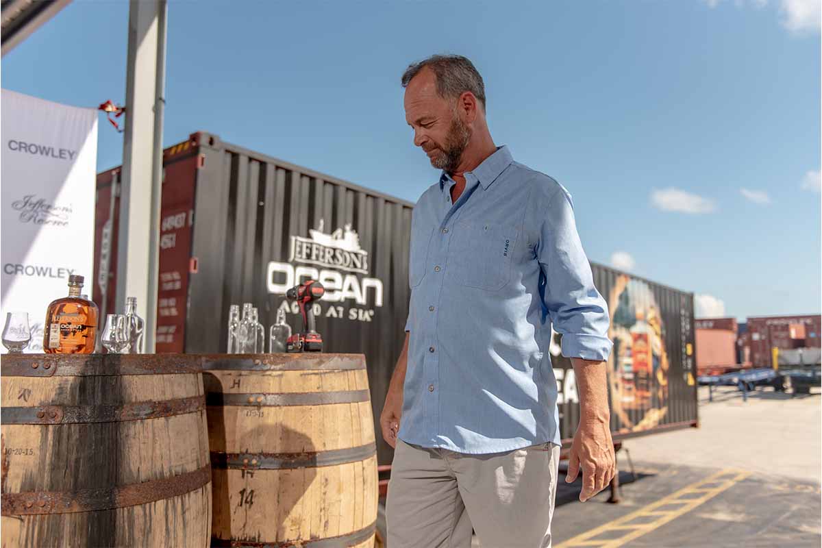 Jefferson's Bourbon founder Trey Zoeller near two whiskey barrels and a truck with the Aged at Sea expressions