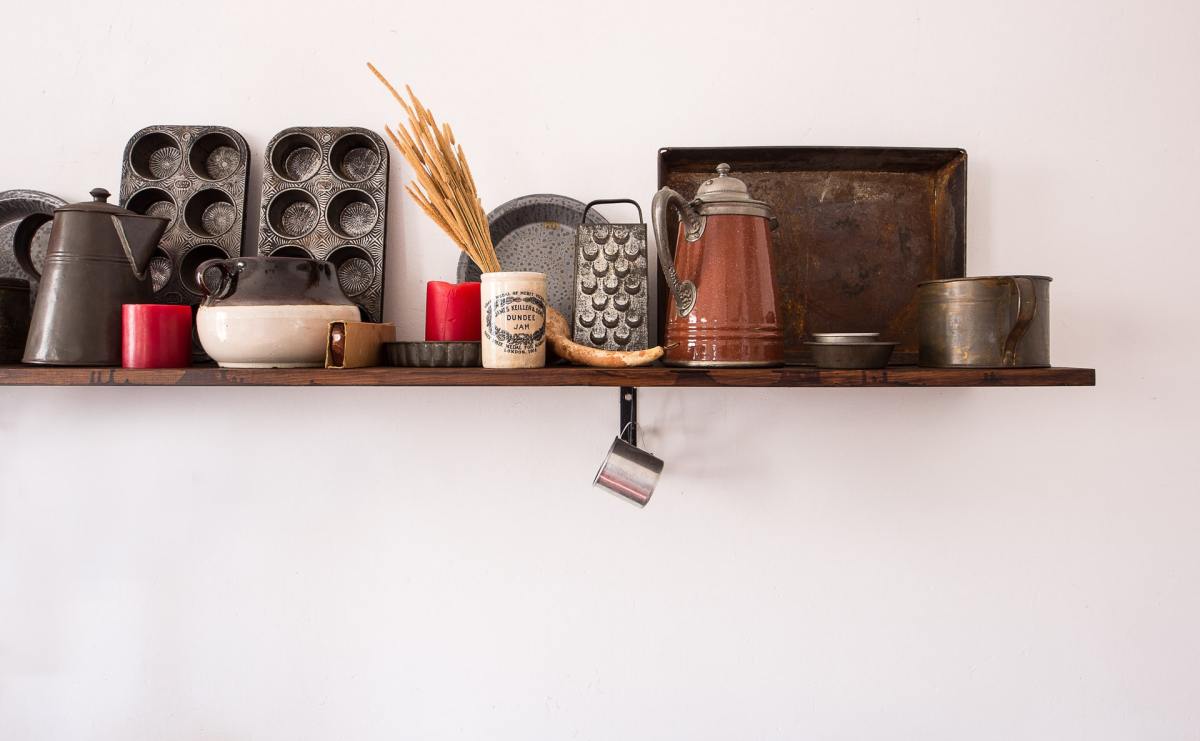 A kitchen shelf with cookware, bakeware and other cooking needs