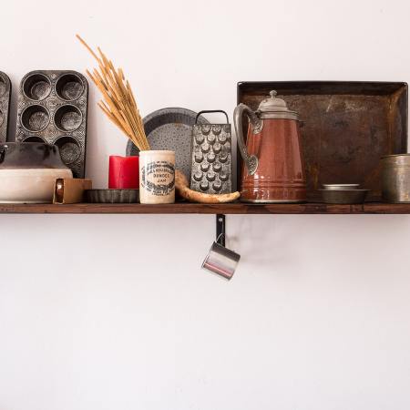 A kitchen shelf with cookware, bakeware and other cooking needs