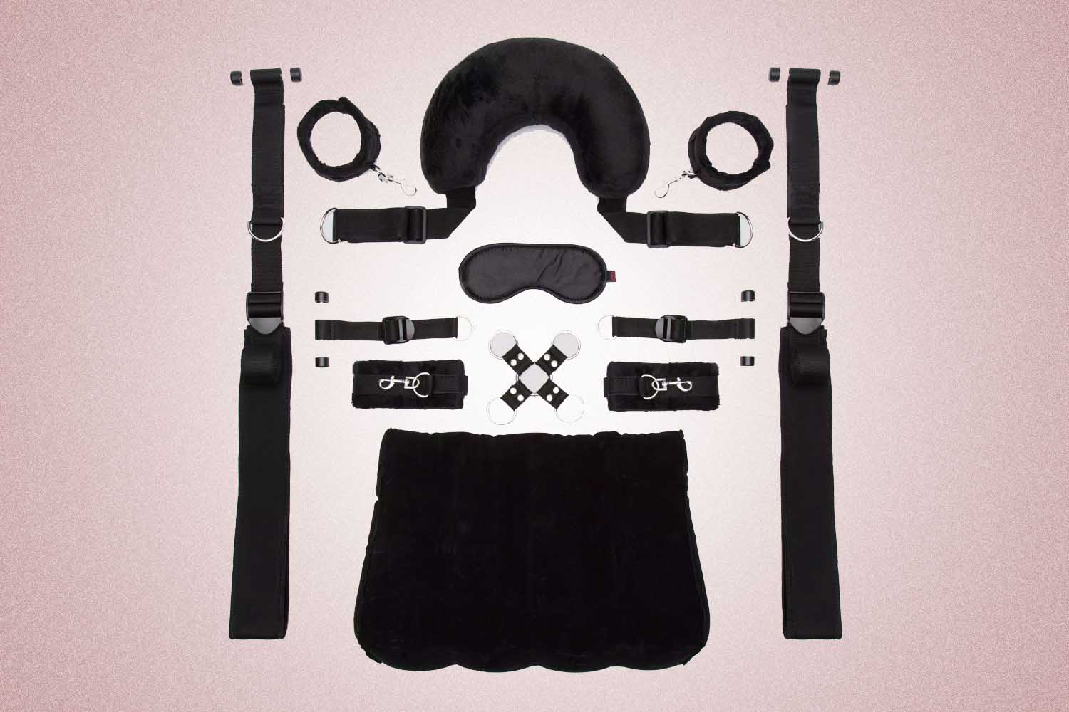 An eight piece black bondage kit from Lovehoney, a perfect Valentine's Day gift, on a pink background. 