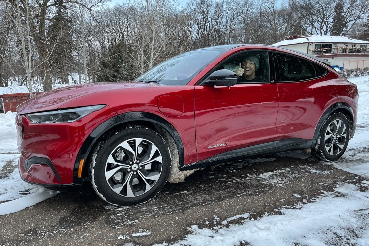 A red 2021 Ford Mustang Mach-E, an electric crossover SUV, in the driveway of a Minnesota home. I idled the EV for 12 hours in for a cold-weather test.
