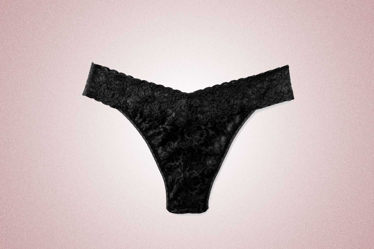 A black lace thong from Hanky Panky, a perfect Valentine's Day gift, on a pink background. 
