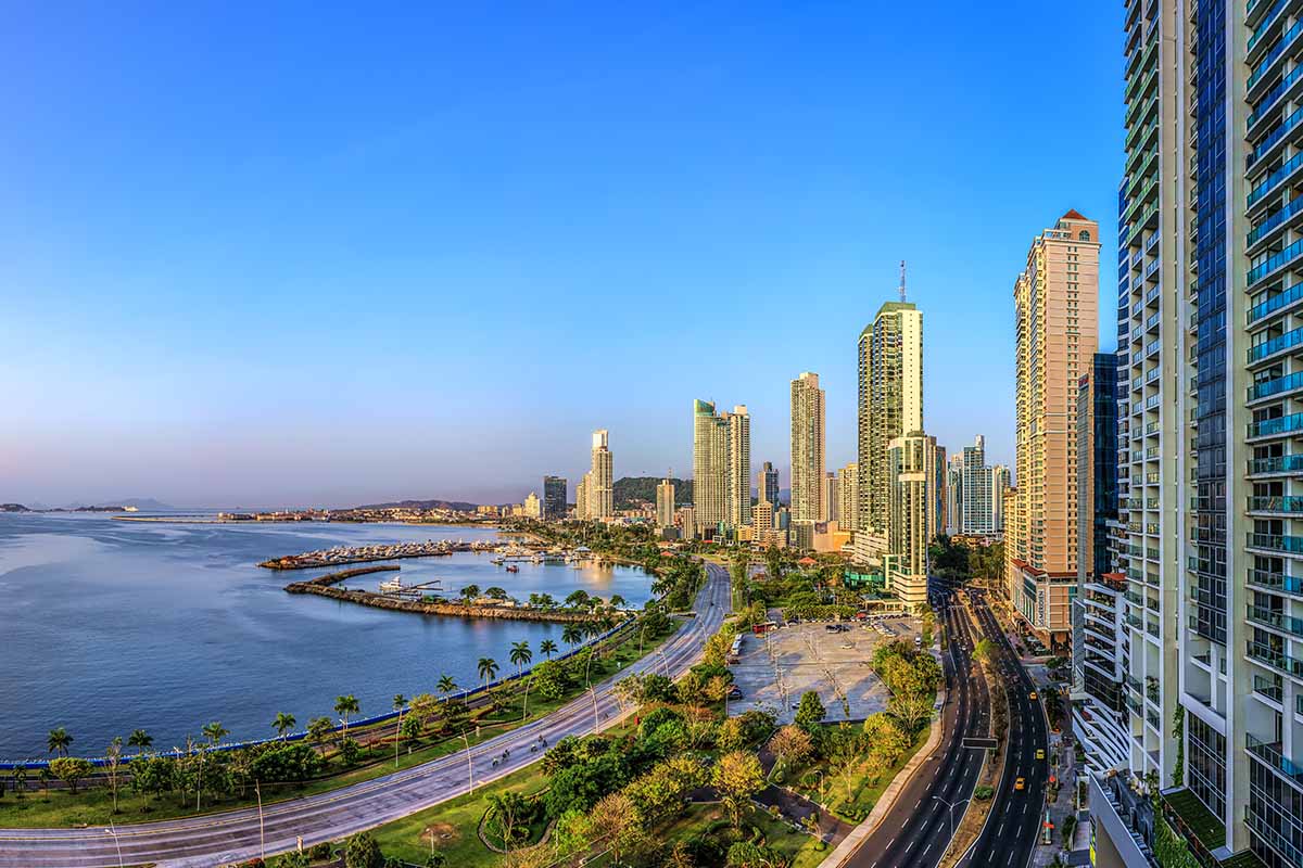Panoramic high angle view of Panama City, high buildings against blue sky, in front blue sea. Panama just topped International Living's Best Places to Retire 2022 list.