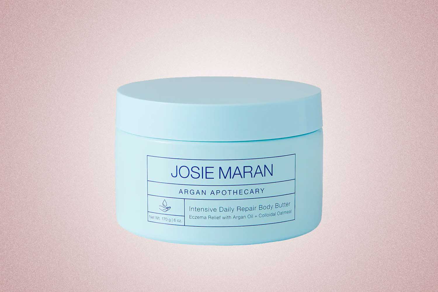 A light blue jar of body butter from Josie Maran, a perfect Valentine’s Day gift for 2022, on a pink background.