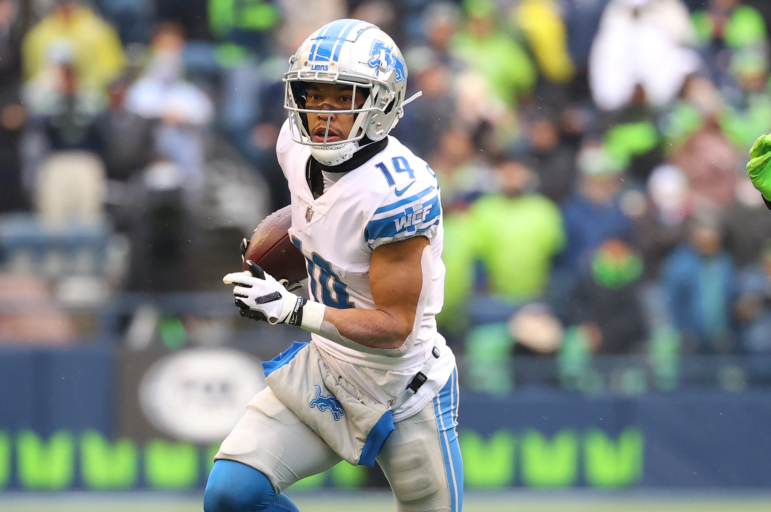 Amon-Ra St. Brown of the Detroit Lions carries the ball against the Seattle Seahawks