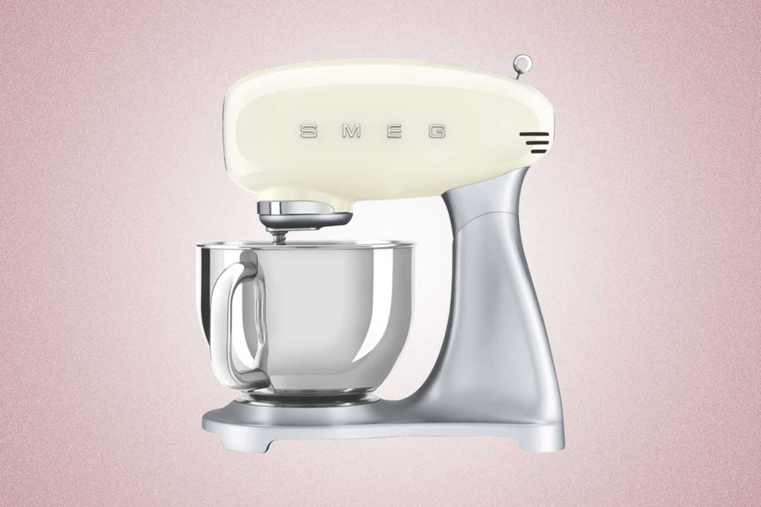 A tan SMEG stand mixer, a perfect Valentine’s Day gift for 2022, on a pink background.
