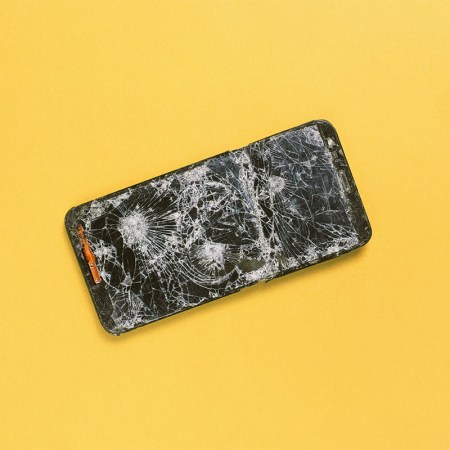 A photo of a cracked phone against a yellow background. Here's what it was like when I went on a 72-hour digital detox from my phone.