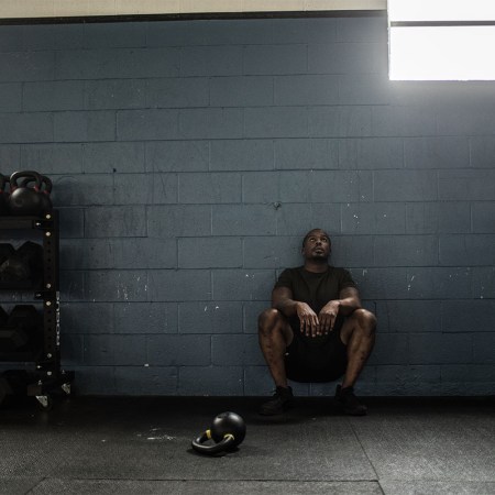 A man resting against the wall in a gym. New studies indicate that people with long COVID have a hard time exercising.
