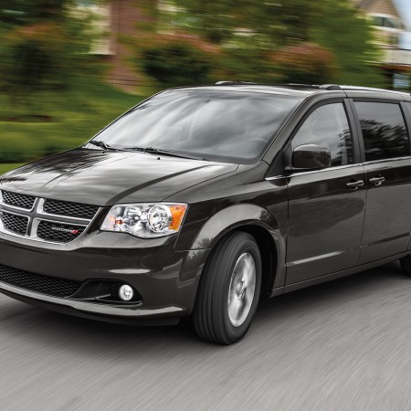 A 2019 Dodge Grand Caravan minivan driving down the road. The price of these used models has increased by 69% between 2021 and 2022.