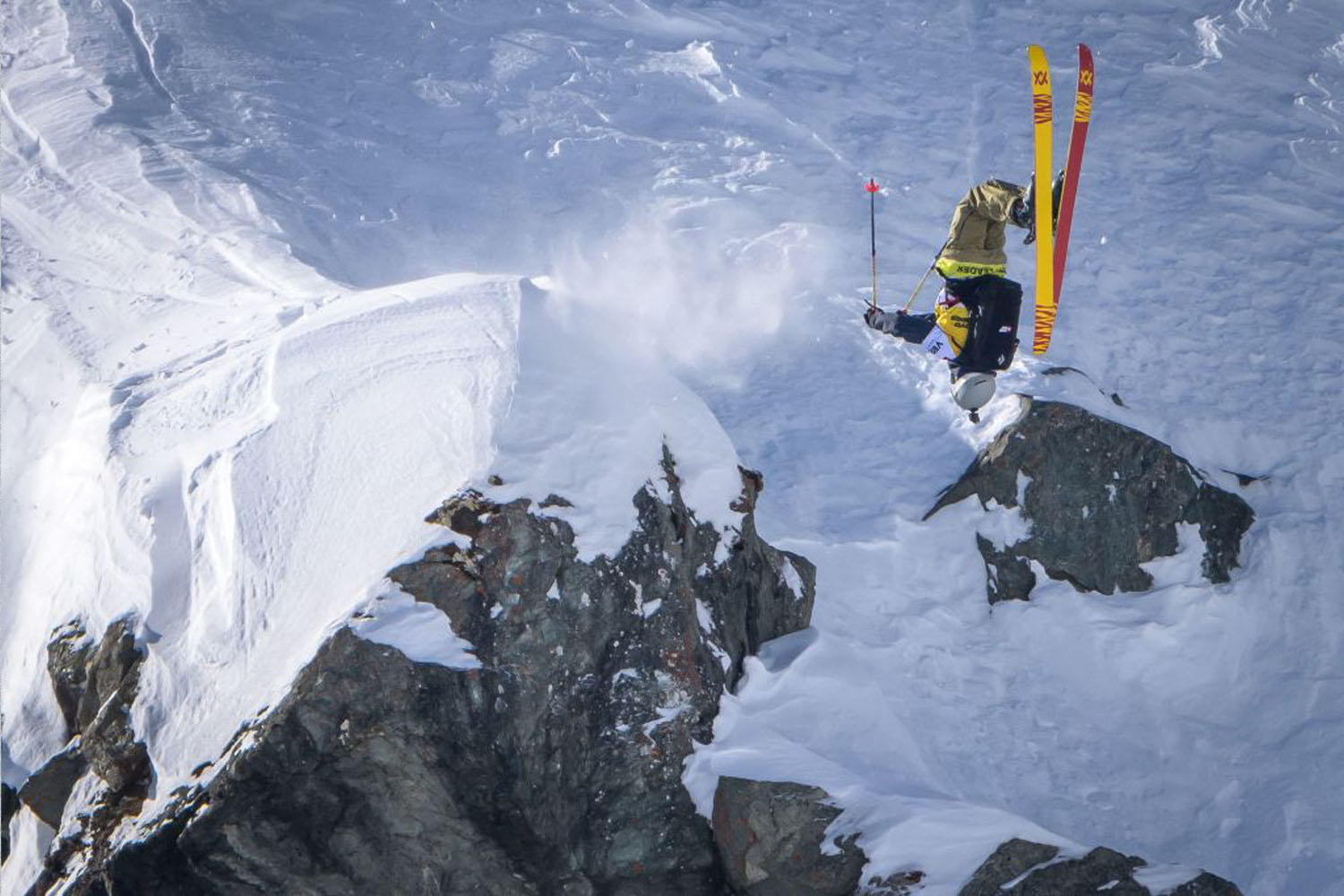 A Freeride World Tour competitor executes a backflip off a natural jump