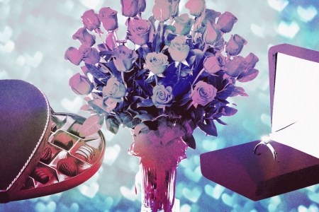 A bouquet of red roses surrounded by a box of chocolates and a diamond ring