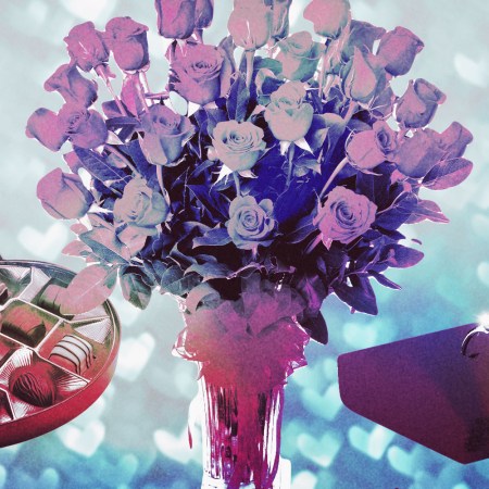 A bouquet of red roses surrounded by a box of chocolates and a diamond ring