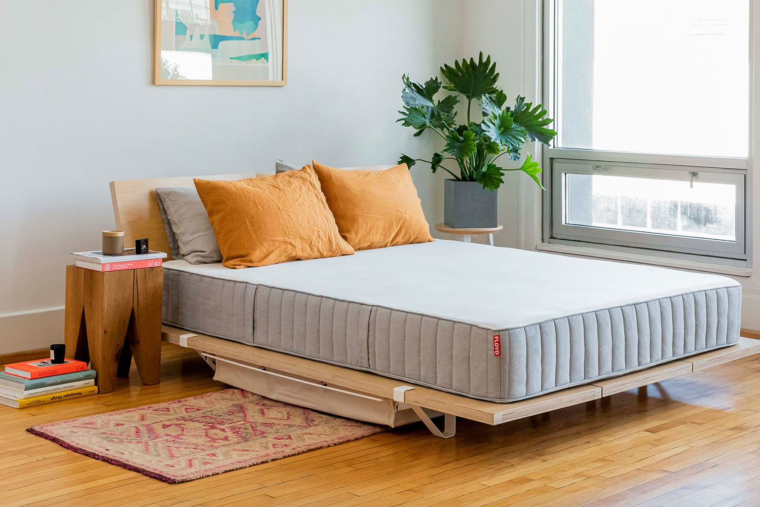 a mattress on a nice wooden frame in a minimal room