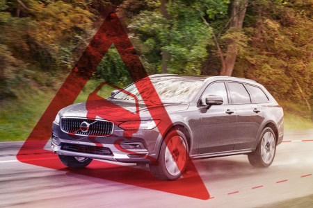 A warning sign hovers in front of the 2022 Volvo V90 Cross Country as it drives down the road. We tested the station wagon's semi-autonomous Pilot Assist system on a road trip.