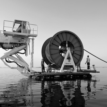 A teams lays an undersea cable to Hiddensee Island in the Baltic Sea