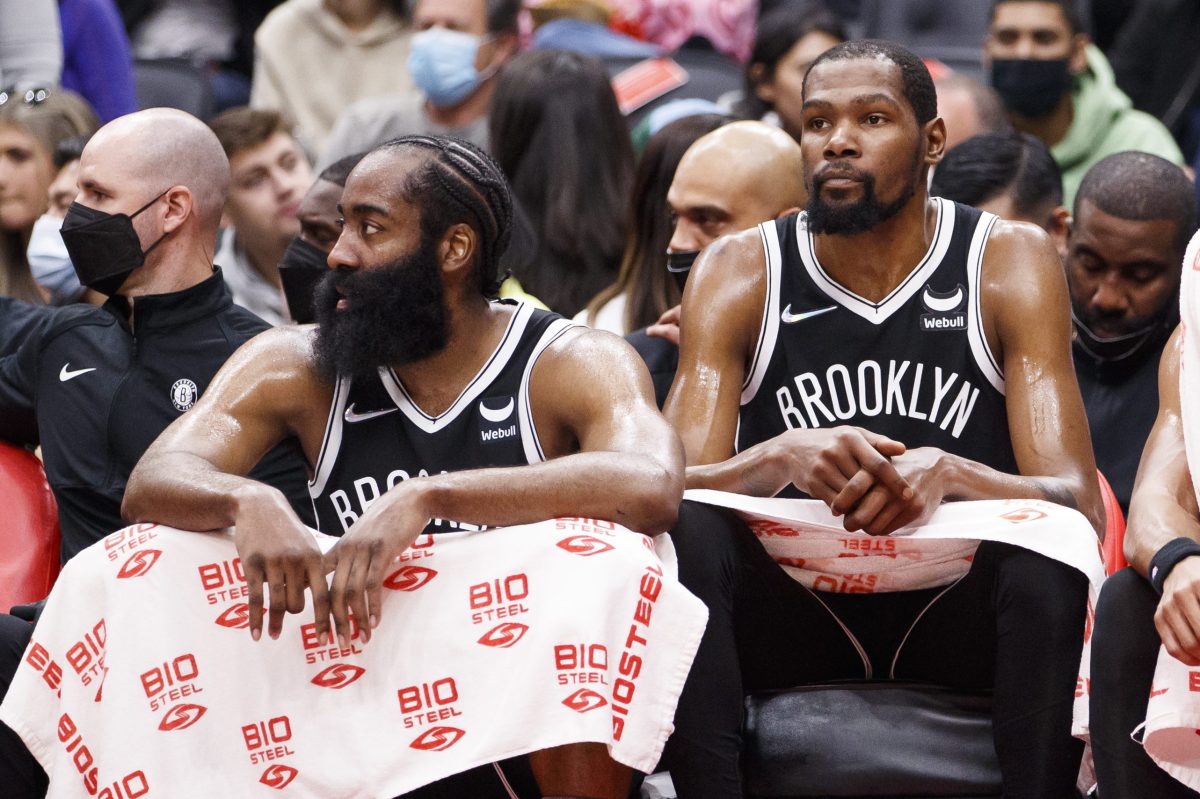 James Harden and Kevin Durant sit on the bench against the Toronto Raptors
