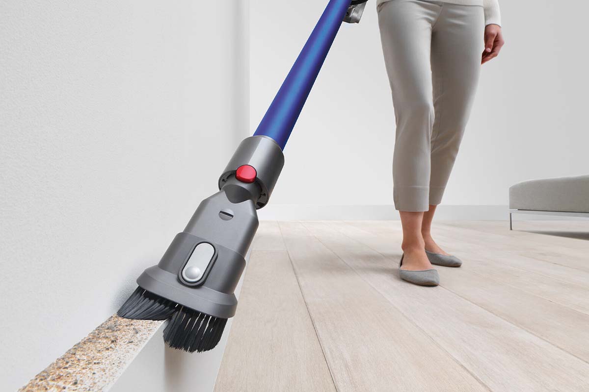 A Dyson vaccum being used on a wall by an unseen person. Dyson products are on sale at eBay.