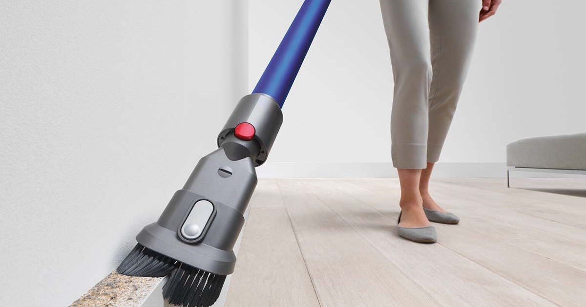 A Dyson vaccum being used on a wall by an unseen person. Dyson products are on sale at eBay.