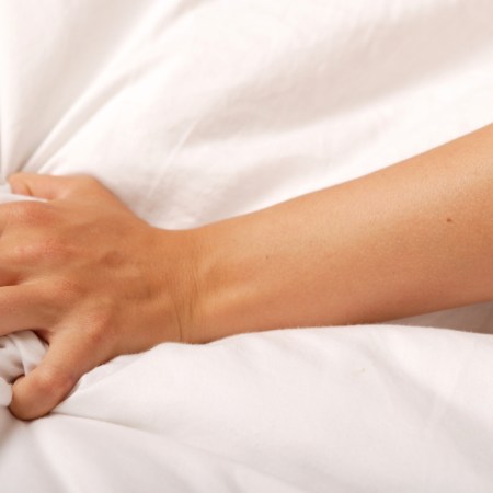 Close-up photo of a woman's hand clutching a sheet