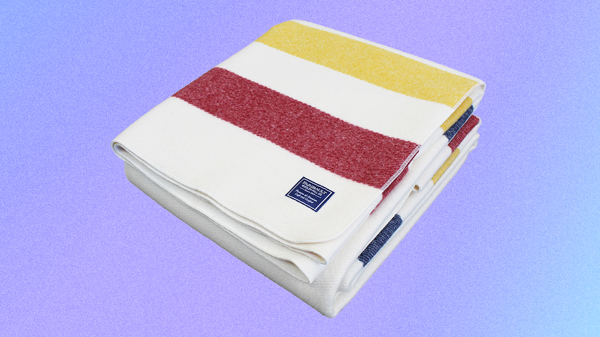 The Frontier Wool Blanket from Faribault Woolen Mill Co. in bone white with red, blue and yellow stripes. The American-made blanket is on sale in February 2022.