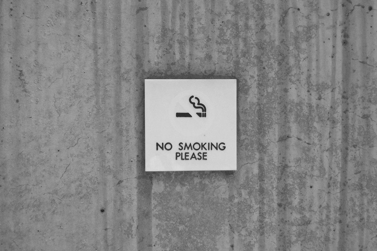 A "No Smoking" sign on a wall. A new article in the Atlantic compares the future the COVID-19 pandemic to how we treat smoking.