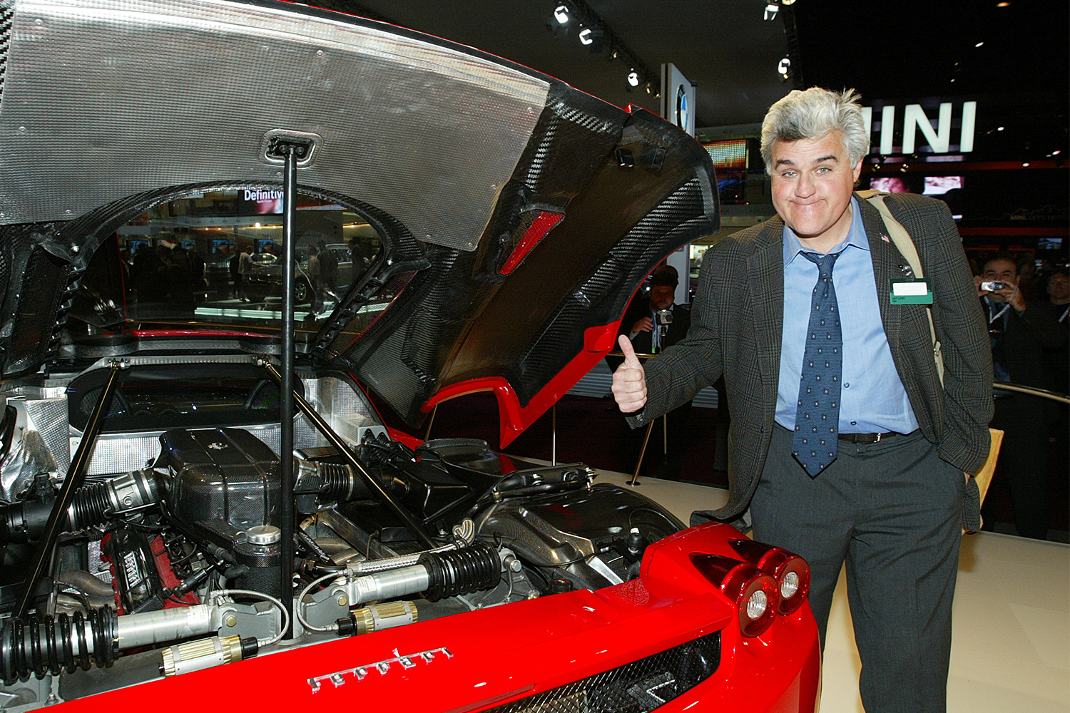 Jay Leno checks out the Ferrari Enzo engine at the North American International Auto Show in Detroit, Michigan on January 5, 2003. In 2021, Leno explained why he doesn’t own a Ferrari.