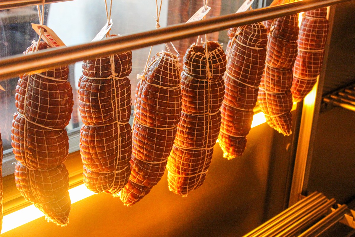 a string of cured meats in the curing room at lardon in chicago