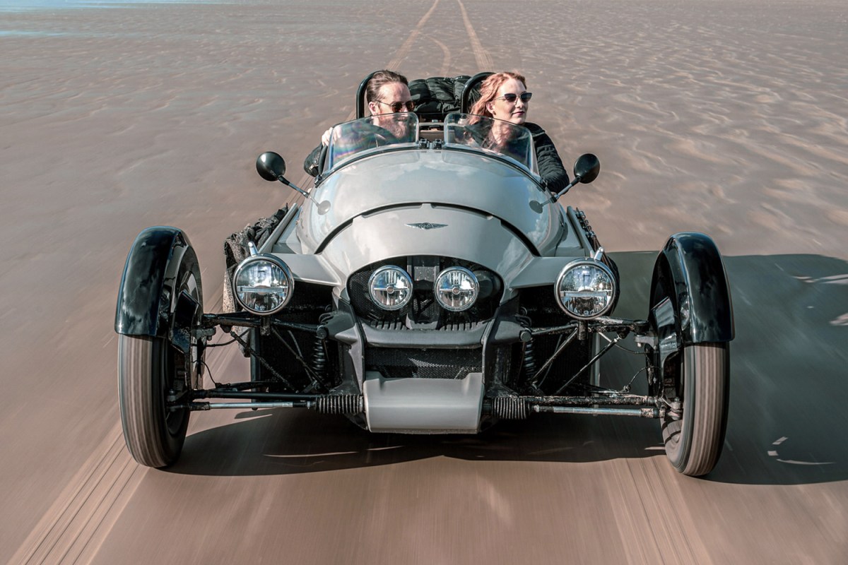 The new Super 3, from England's Morgan Motor Company. The three-wheeler is seen here with two passengers being driven on the sand.