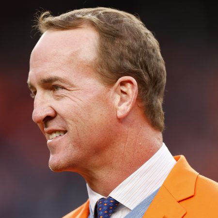 Peyton Manning looks on during a Ring of Honor induction ceremony at Empower Field At Mile High. ESPN recently announced that the format of his "Manning Cast" with Eli will be expanded to other sports, including golf and UFC.