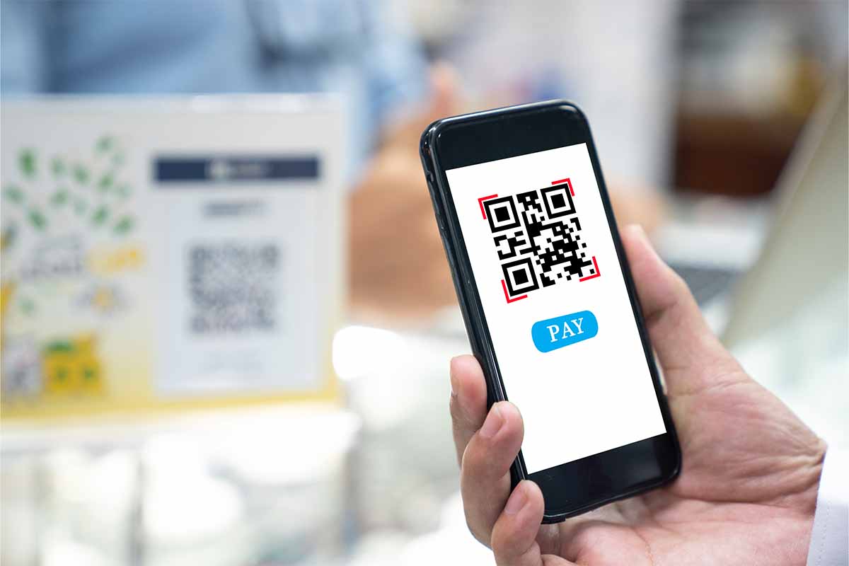 A person holding up a smartphone and scanning a QR code. In January 2022, the FBI warned about scammers manipulating QR codes.