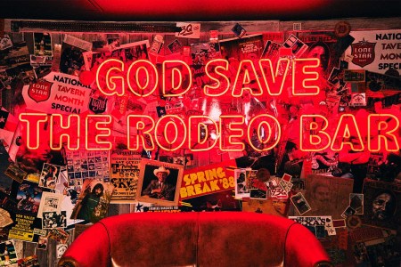 A neon sign "God Save the Rodeo Bar"
