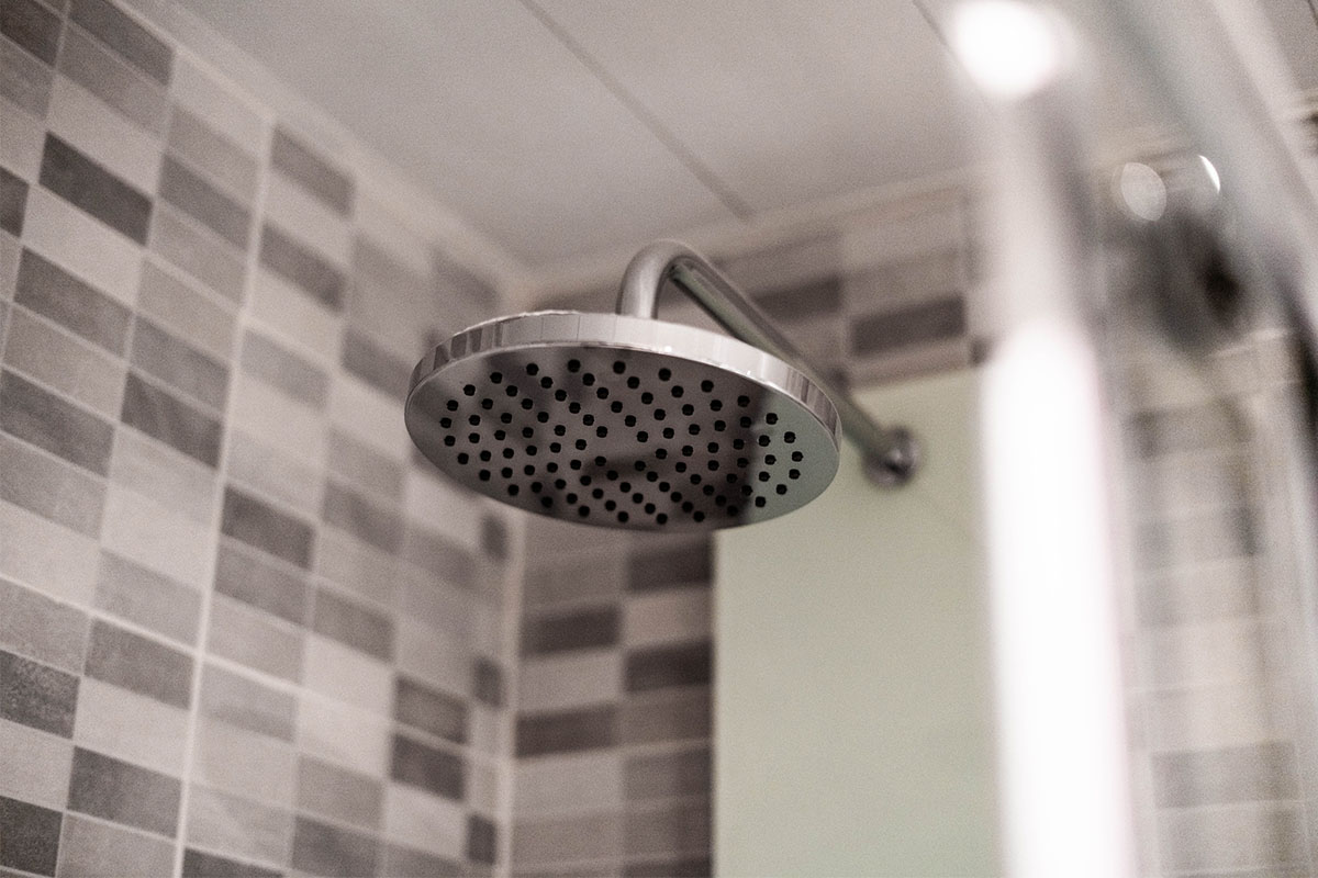 A dry shower head. Here's why you should consider showering less, or not at all.