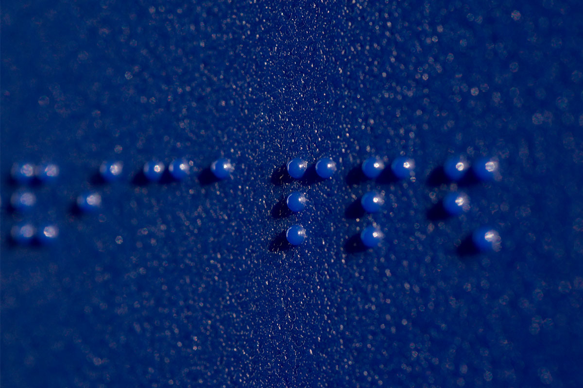 Braille on a blue bathroom sign. Looking at the science around blindness, in 2022 we have more potential cures than ever.