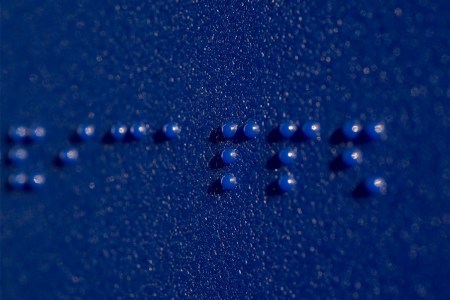 Braille on a blue bathroom sign. Looking at the science around blindness, in 2022 we have more potential cures than ever.