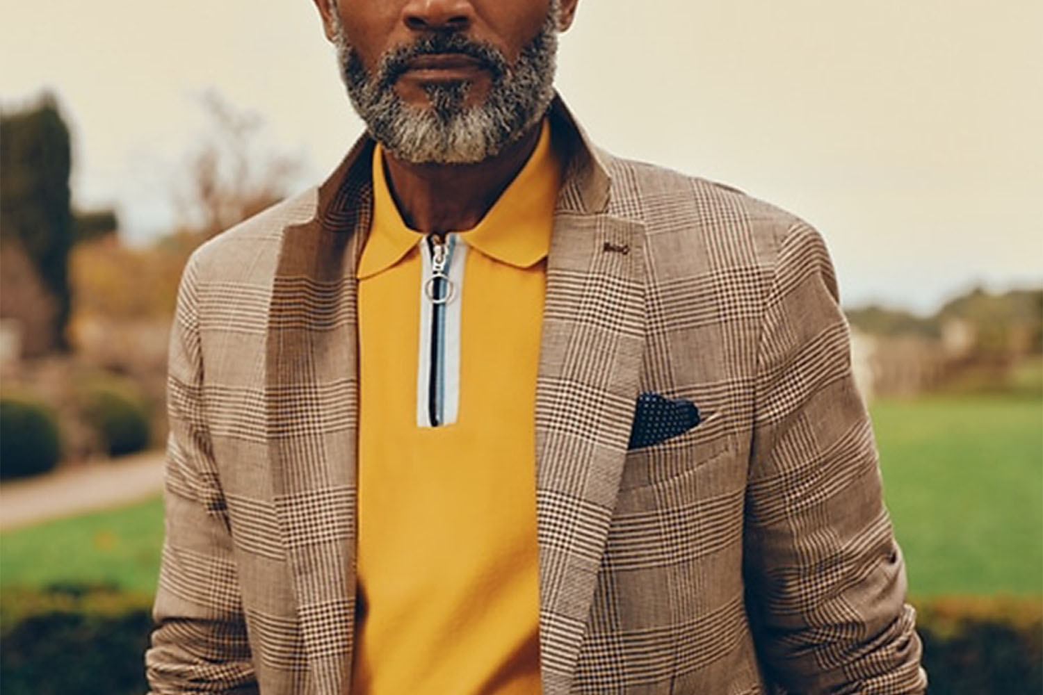 a yellow zip polo and tweed jacket on a model