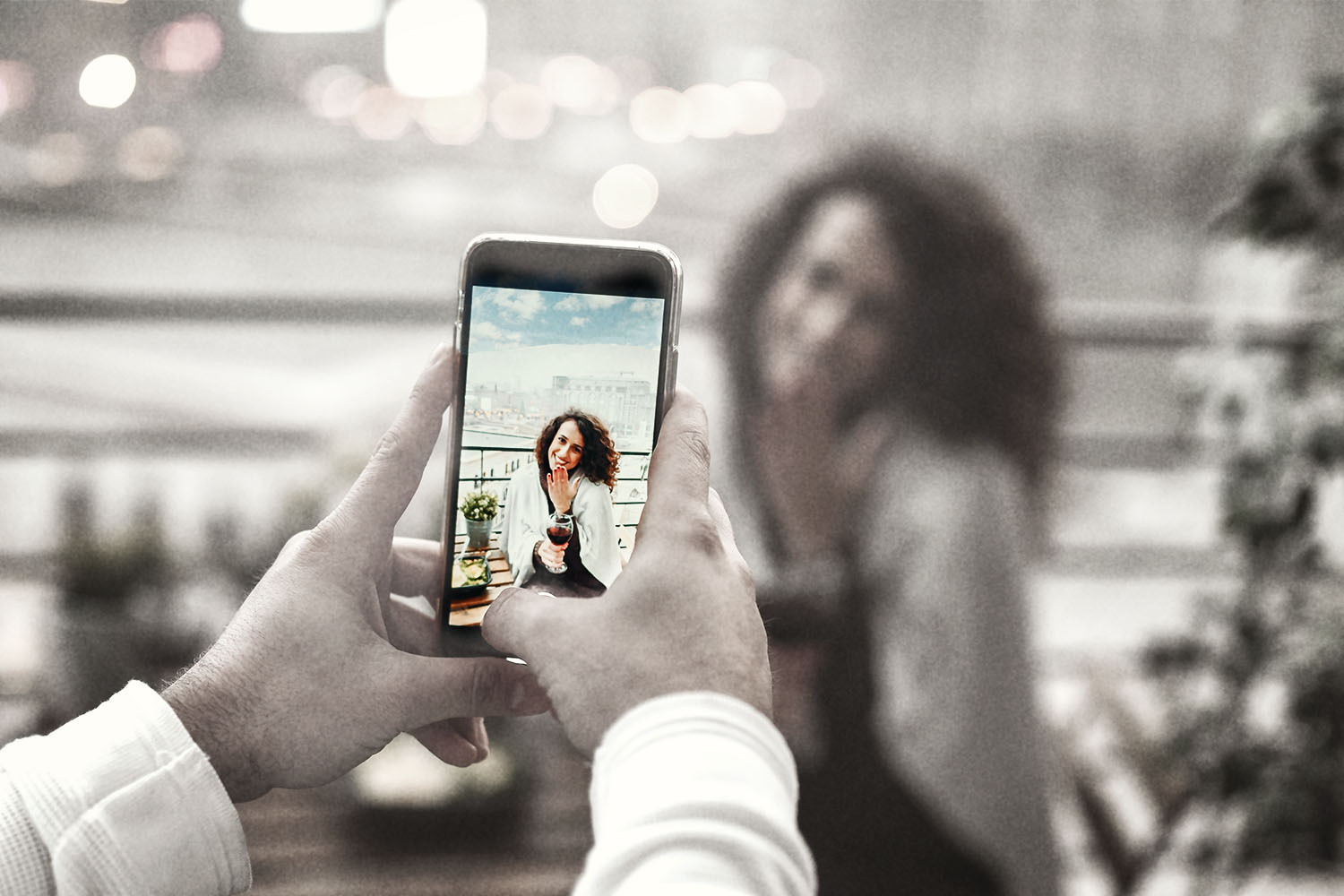 A man takes a photo of a woman on a smartphone