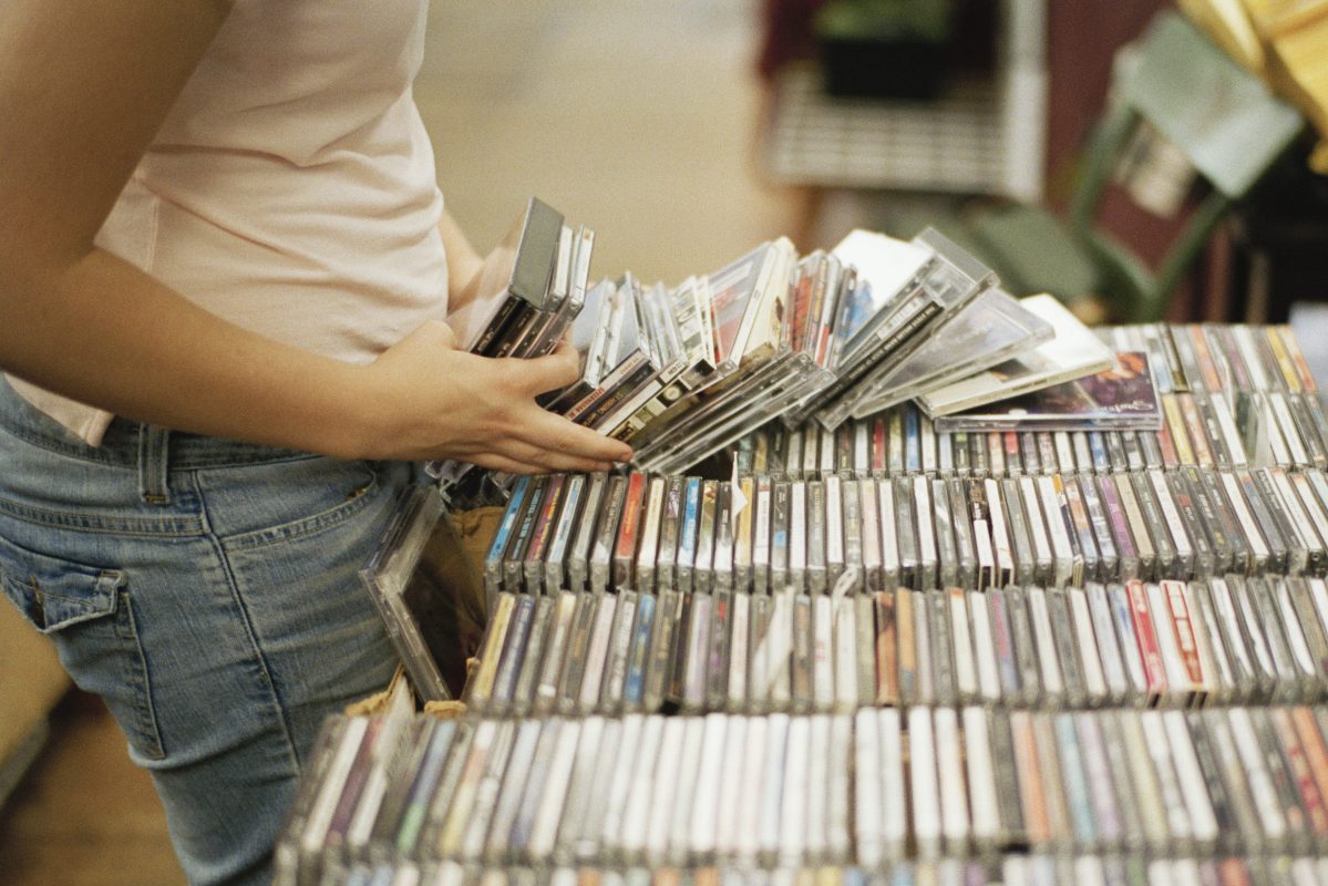 A woman flipping through a stack of CDs in a record store. According to the Recording Industry Association of America, CD sales in the U.S. rose in 2021 for the first time since 2004.