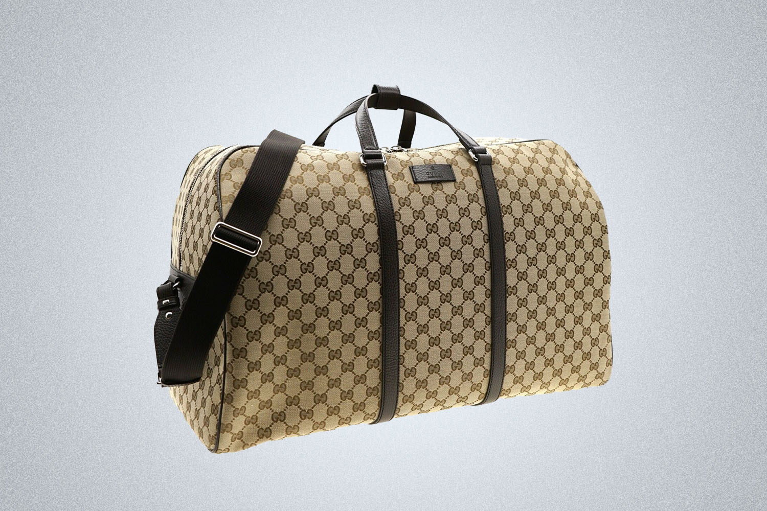 A Gucci duffle bag on a grey background 