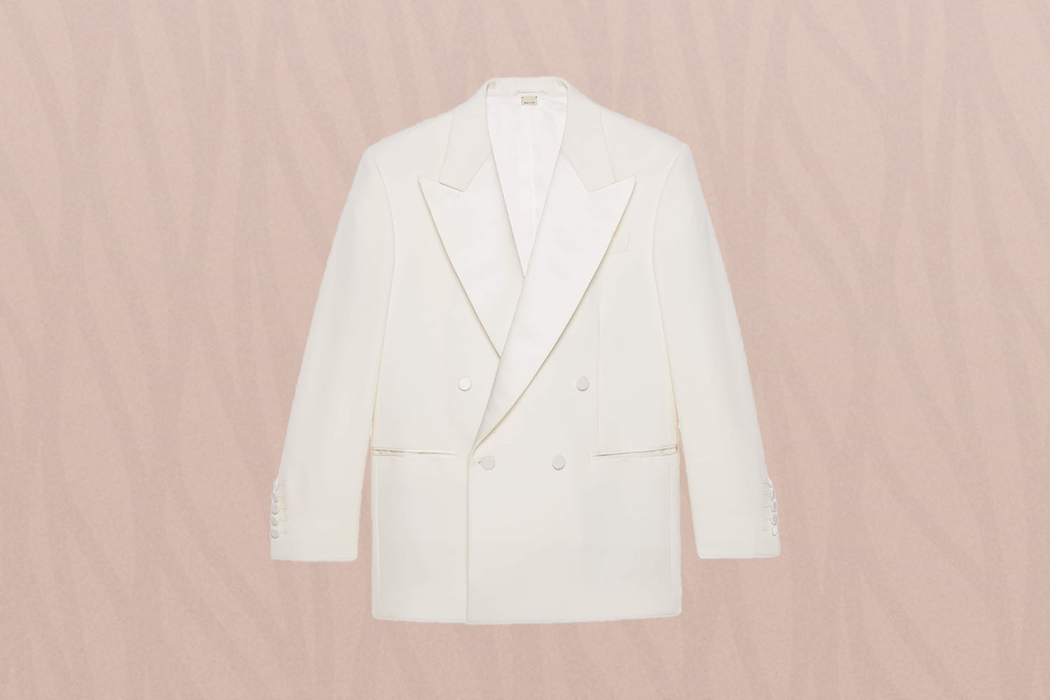 an off-white blazer on a pink background 
