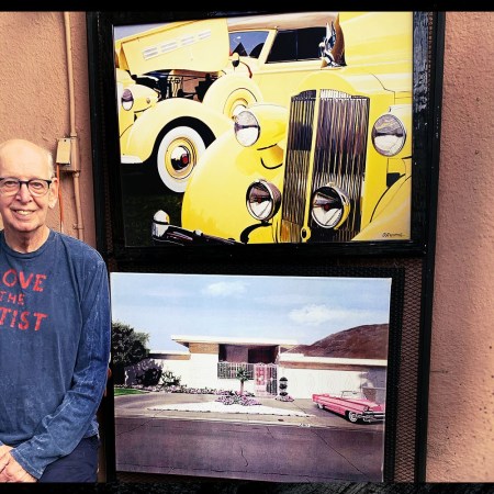 Painter Harold Cleworth, from Manchester, UK, but living in Venice Beach, California, sitting next to two paintings of cars. He's known for painting classic cars for their well-heeled owners.