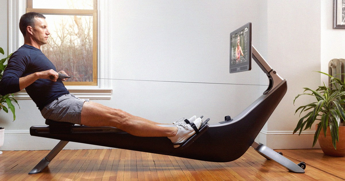 Man using Hyrow rowing machine in living room in 2022. They just opened a new flash sale — here's how to get a discount in March 2022.