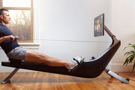 Man using Hyrow rowing machine in living room in 2022. They just opened a new flash sale — here's how to get a discount in March 2022.