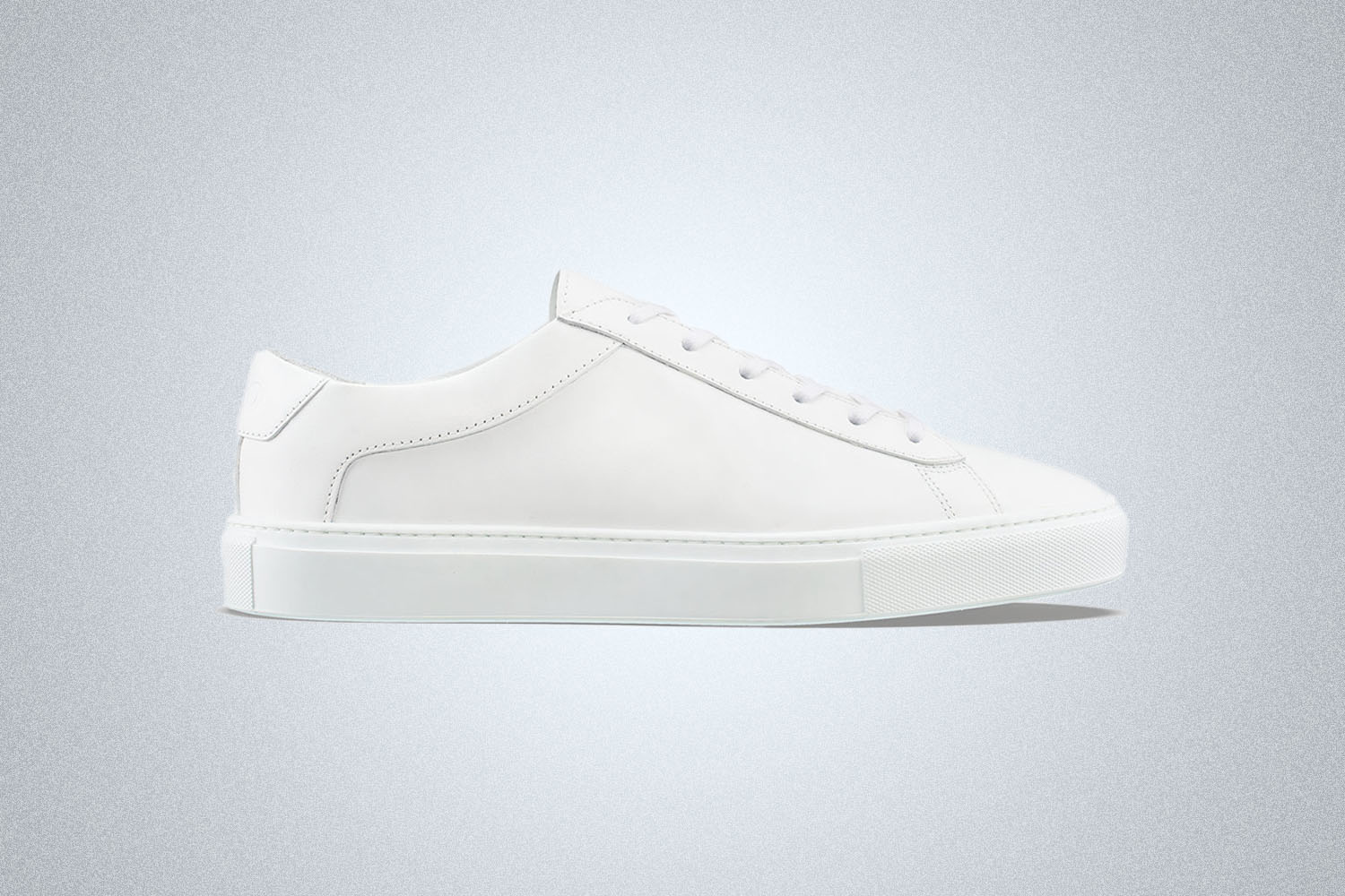 a pair of white sneakers on a grey background
