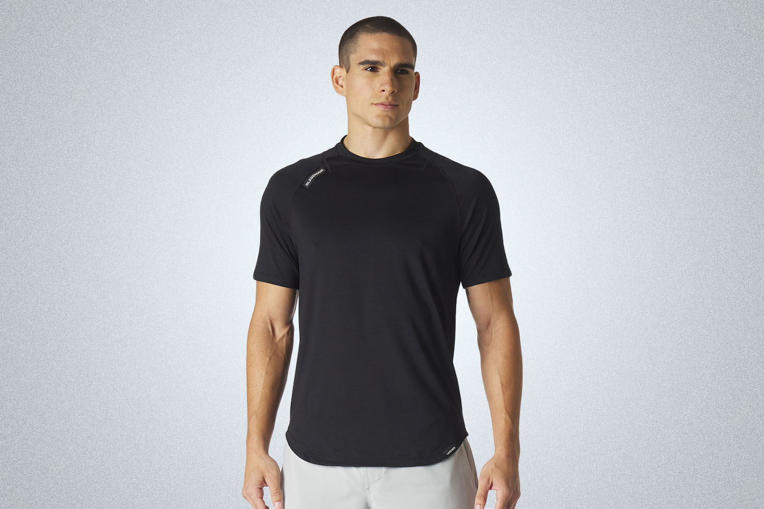 a model in a black tee on a grey background