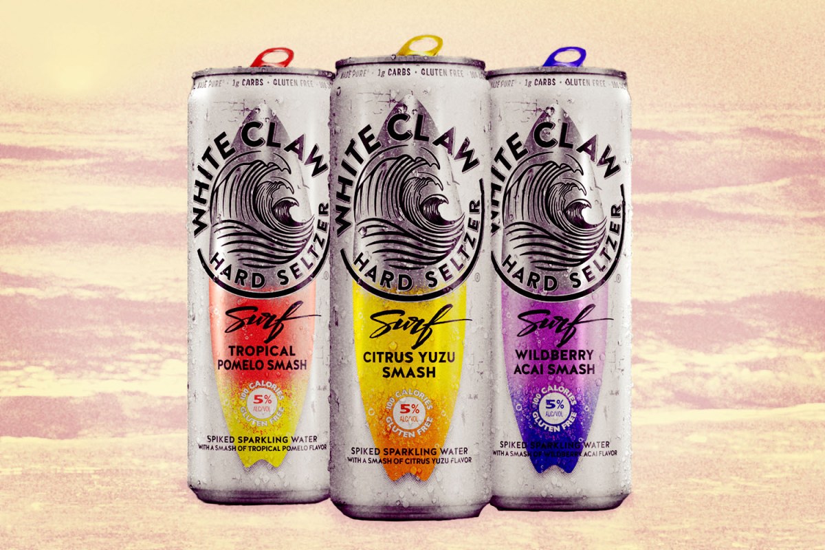 Three cans of White Claw Surf and a background of the ocean.