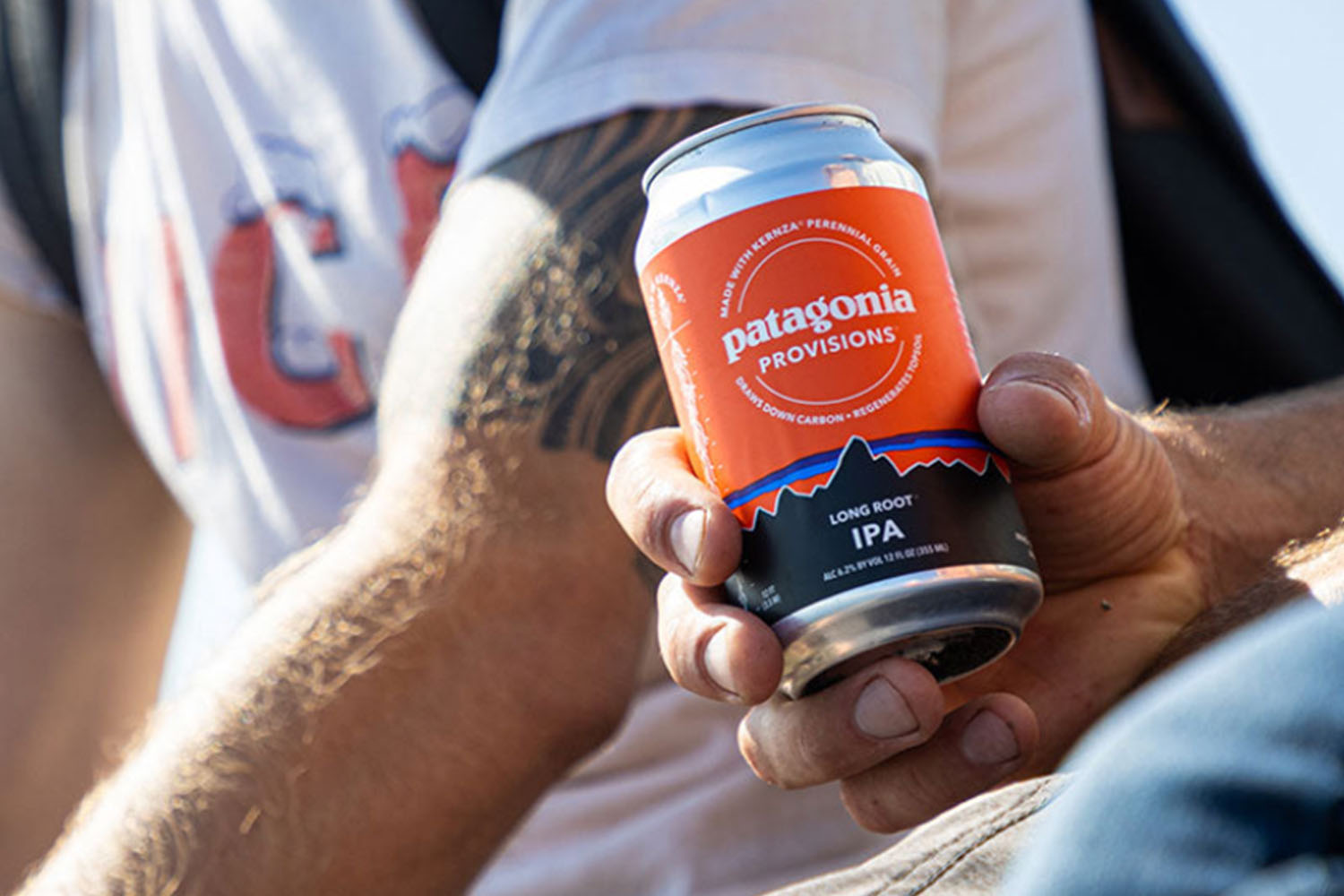 a handle holding a can of Patagonia beer 