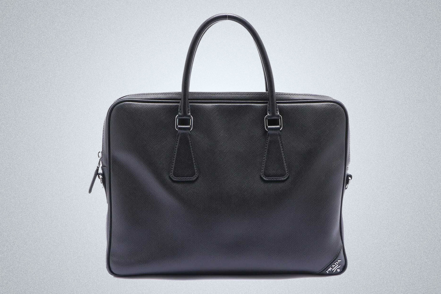 a Prada travel bag on a grey background