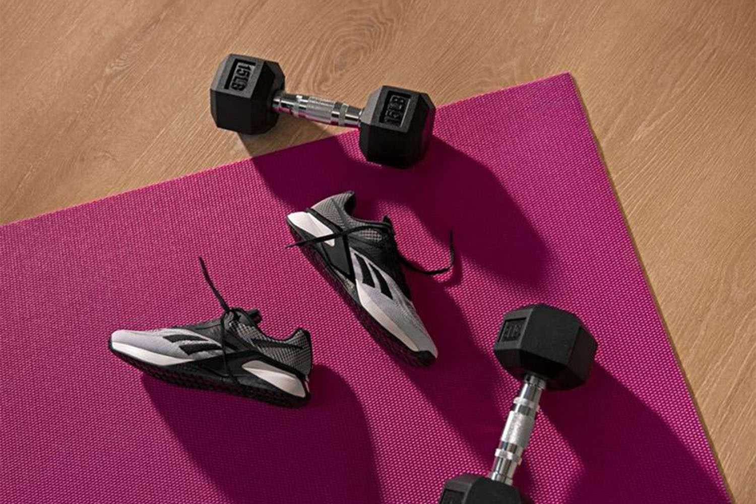 a pair fo sneakers on a yoga mat with weights